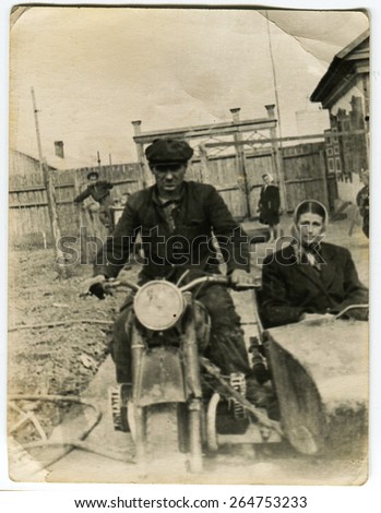 Ussr - CIRCA 1970s: An antique Black & White photo show husband and wife on a motorcycle