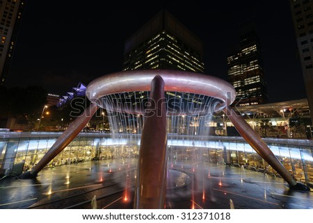 SUNTEC CITY, SINGAPORE - JULY 23, 2015: Traffic around Fountain of Wealth at evening. Fountain of Wealth is one of the largest fountain in Asia.