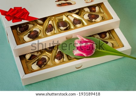 A beautifully decorated and tied with a ribbon box of chocolates, gift by a holiday, celebration, anniversary.