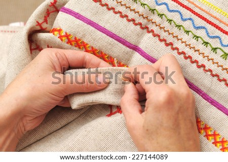 Woman hands sewing with needle and thread