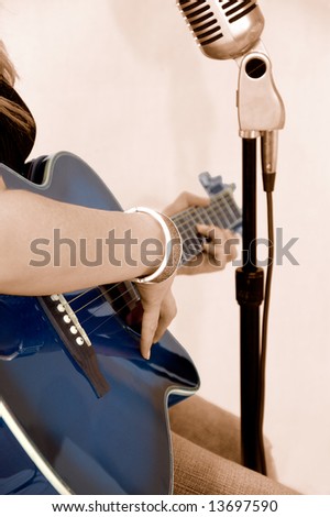 Female rock singer in Sepia with blue guitar on white background
