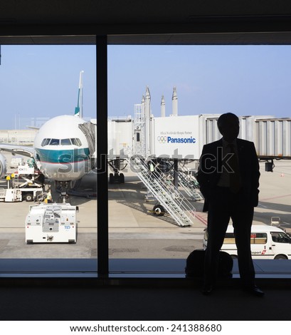 Osaka, Japan - Nov 7: Silhouette of a businessman waiting to board a Cathay Pacific passenger airplane in the Kansai International Airport in Osaka, Japan on Nov 7, 2014.