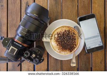 Melbourne, Australia - Oct 1, 2015: Top down view of a cup of coffee , camera and an iPhone running the Notes app.