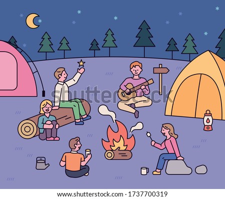 Friends sit around a campfire and have a romantic camping trip. flat design style minimal vector illustration.