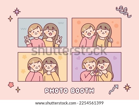 Two girls are taking pictures in various poses. Photo booth.