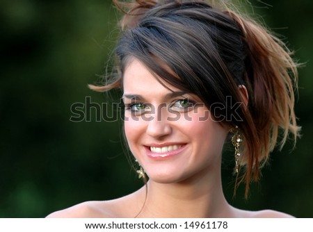 Beautiful smiling young woman with green eyes on green background