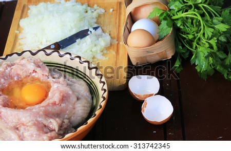 Chicken ground meat for meatballs eggs chopped onion garlic wood background texture old retro vintage home cooking knife diet low weight