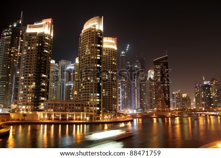 Scenic view of illuminated of Dubai city at night with boats, United Arab Emirates