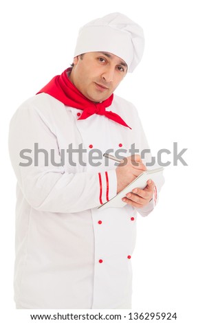 cook man writing something in notebook with pen wearing red and white uniform in the studio over white background