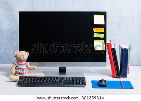 workspace with doll, books, post it and pencil