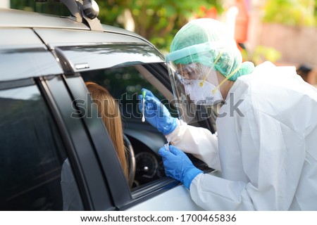 Doctor or nurse wearing PPE, N95 mask, face shield  and personal protective gown standing beside the car/road screening for Covid-19 virus, Nasal swab Test.  Photo stock © 