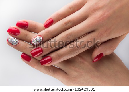 red nails with crystals and hands isolated on white background