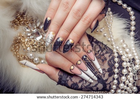 Retro jewels and extreme long nails on white fur. Gatsby, Vintage style