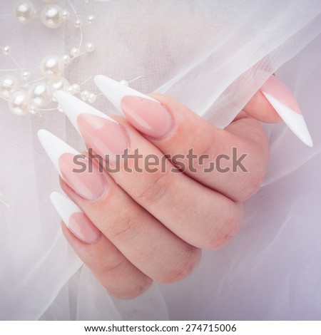 Painted extreme long nails and hands isolated on white silk background
