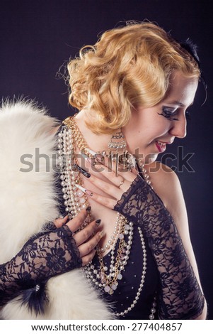 Retro portrait of beautiful happy blonde woman with jewels and extreme long nails. Gatsby, Vintage style. Isolated on black background