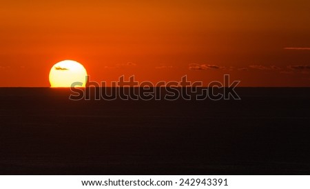 The very red sun rising over the ocean