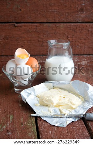 butter, milk and eggs on wooden boards