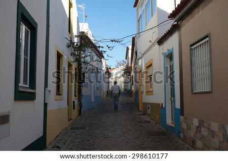 man walking down a cobblestone street