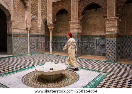 FEZ, MOROCCO - DECEMBER 24: Islam worshipper crossing the Bou Inania Madrasa, the famous and old islamic college, in Fez,on December 24, 2014 in Fez, Morocco.