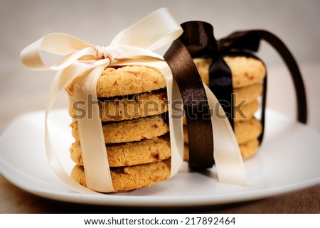Close up of stacked apple chip cookies taped with silk ribbons on white china plate