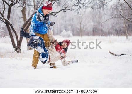 Guy and girl walk and have fun in the forest in winter