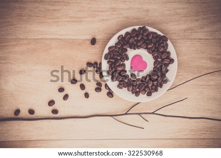 idea coffee beans with pink heart on vinyl wooden background/ dark tone