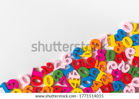Colorful wooden numbers on part of background with copy space. Numbers texture abstraction on part of board. Top view of multicolor numbers from zero to nine. Mathematic topic. Back to school concept