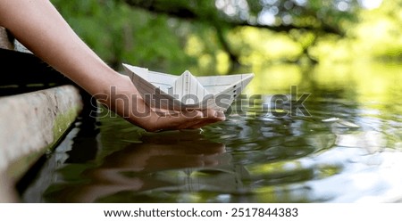 Similar – Foto Bild Zwei gelb-blaue Papierboote in weiblichen Palmen auf grauem Hintergrund