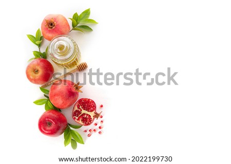 Pomegranates, apples and honey on white background, traditional food of Jewish New Year - Rosh Hashanah.Top view. Copy space background