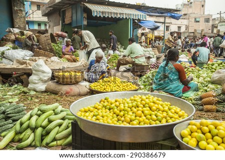 BANGALORE, INDIA - May 27, 2014: Fresh limes ready to be sold in the city vegetable market, vendors in theor stalls in the background