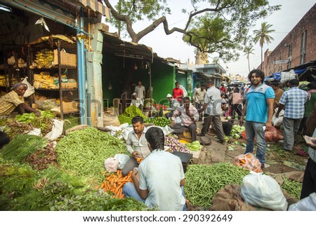 BANGALORE, INDIA - May 13, 2014: a group of vendors sort through green vegetables and herbs for selling them in the market