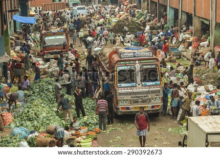 BANGALORE, INDIA - May 27, 2014: BANGALORE, INDIA - May 27, 2014: Aerial view of the crowded city market, vendors sell vegetables, vehicles move through the crowd