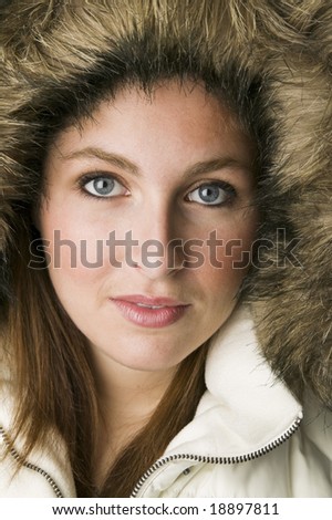 Close up portrait of a pretty woman wearing fur parka