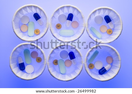 Dispensing cups containing groups of pills for patients