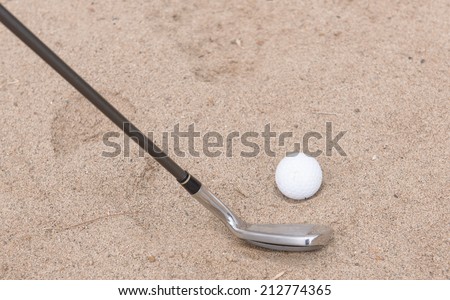 Golf ball falling into the sand trap.