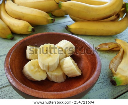Banana slices placed in a wooden bowl.