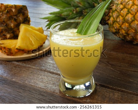 pineapple juice and pineapple on wood table. for health