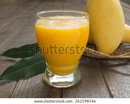 mango juice and mango on wood table