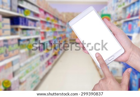 Human hand hold and touch screen smart phone, tablet,cellphone on blurred Shopping mall background; With clipping path on screen Smart Phone.