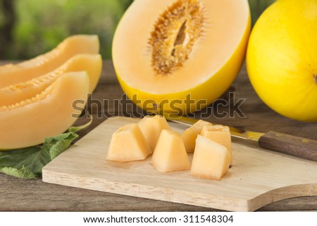 Fresh yellow melon sliced  ( Canary melon or winter melon) pieces in wood plate; Selected focus.