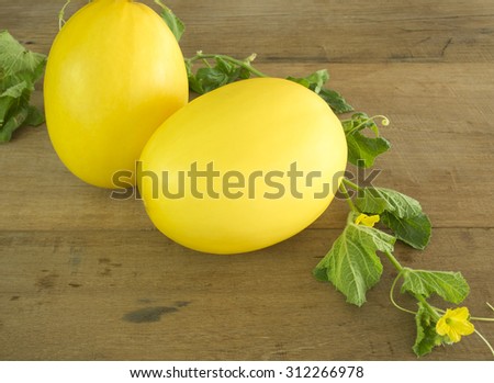 Fresh yellow melon ( Canary melon or winter melon) placed on a wooden table.