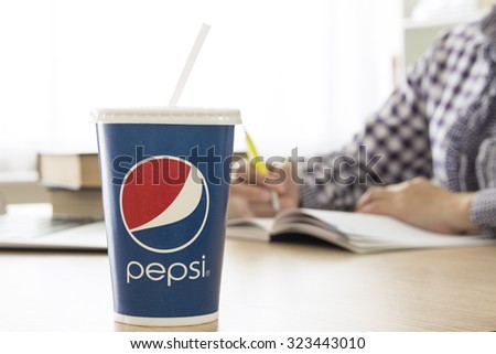 Bangkok, Thailand - Oct 4, 2015 : Pepsi soft drinks paper cup on the table with Natural background bokeh. Pepsi brand is one of the world famous soft drinks chains from USA.
