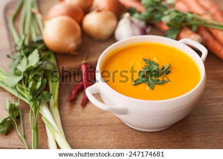 carrot soup with vegetables on wood table