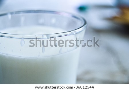 Glass of sour milk with slightly noticeable yellow leaf