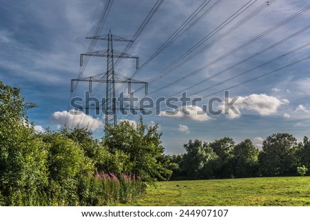 Electricity energy tower in landscape with green trees blue sky \
Electricity energy tower with many cables in landscape with green trees blue sky background