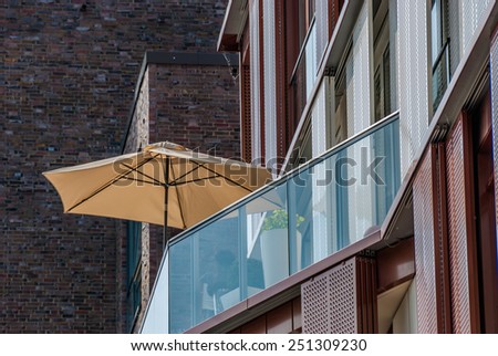 Beach umbrella on an apartment patio Hamburg Germany Sunshade or beach umbrella on a modern apartment patio with glass enclosure for a healthy outdoor lifestyle, view from below