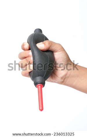 The hand holding the air blower cleaning a camera with white background