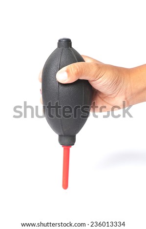 The hand holding the air blower cleaning a camera with white background