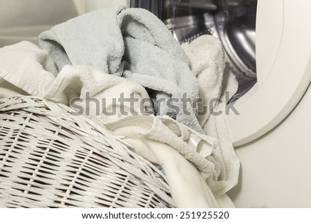 Towels in the laundry basket in front of the washing machine