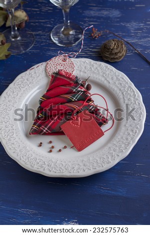 Christmas Dinner rustic, white plate, and napkin red boxes in the shape of tree, Blue background